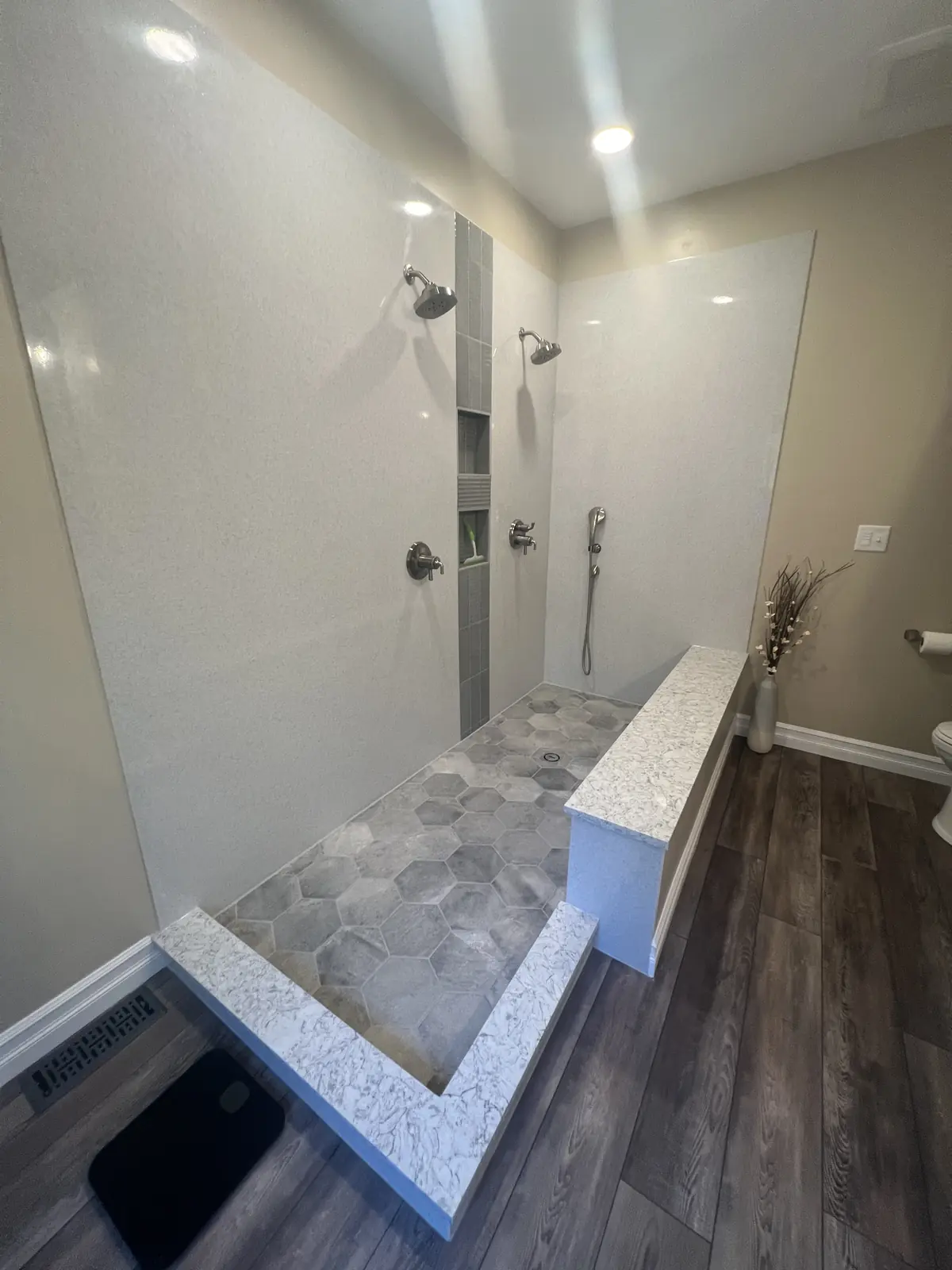 Double walk-in shower with bench and hex tile floor